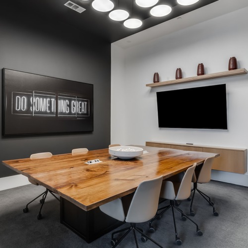 a room with a tv, table and chairs