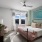 natural light pours through large windows in carpeted bedroom